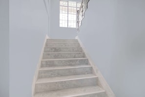 Un escalier avec une rampe et une fenêtre en haut.