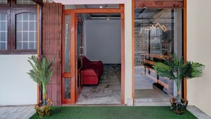A modern interior with a red sofa, a wooden door, and a glass partition.