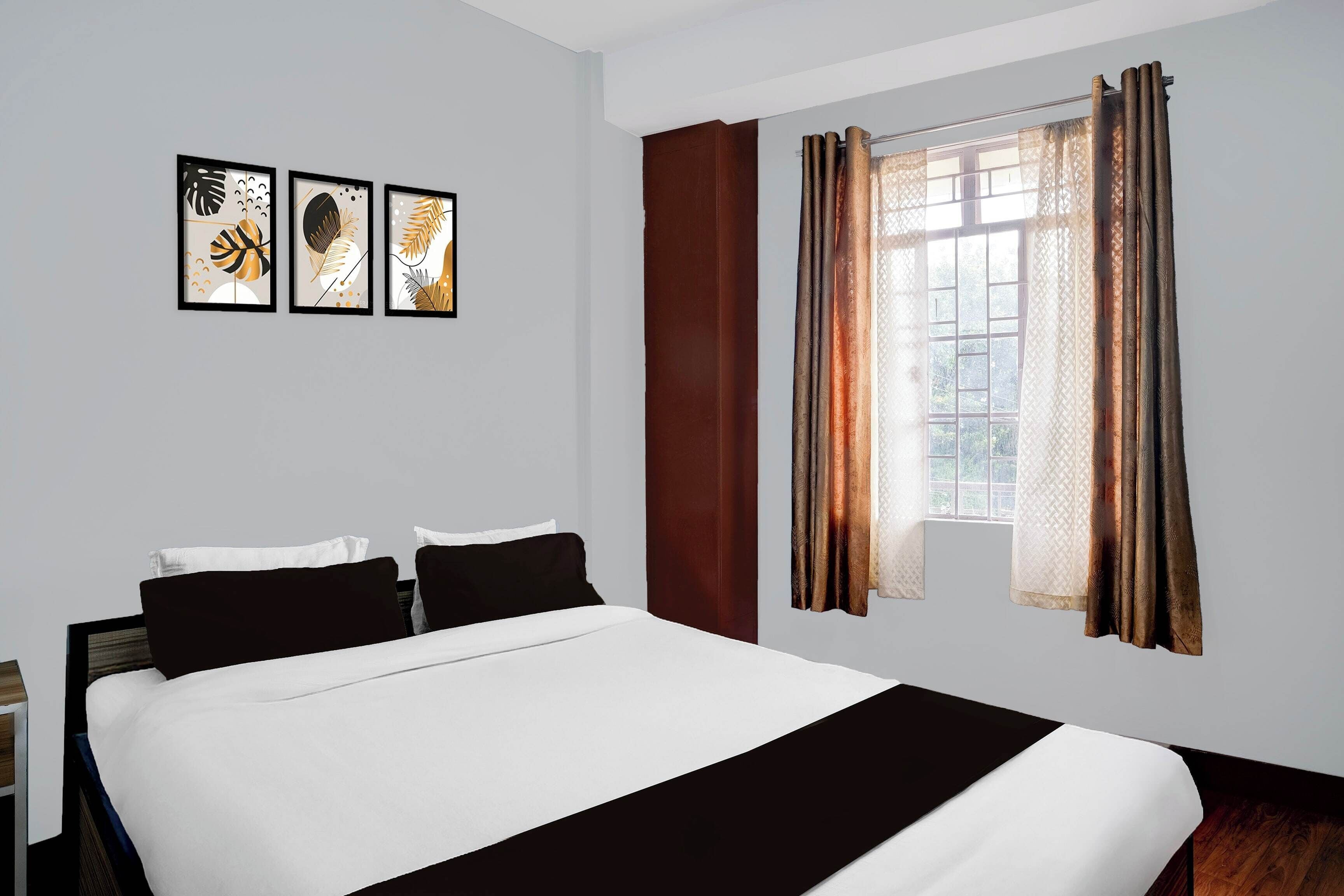 Una habitación de hotel con una cama, una mesita de noche y una ventana con cortinas.