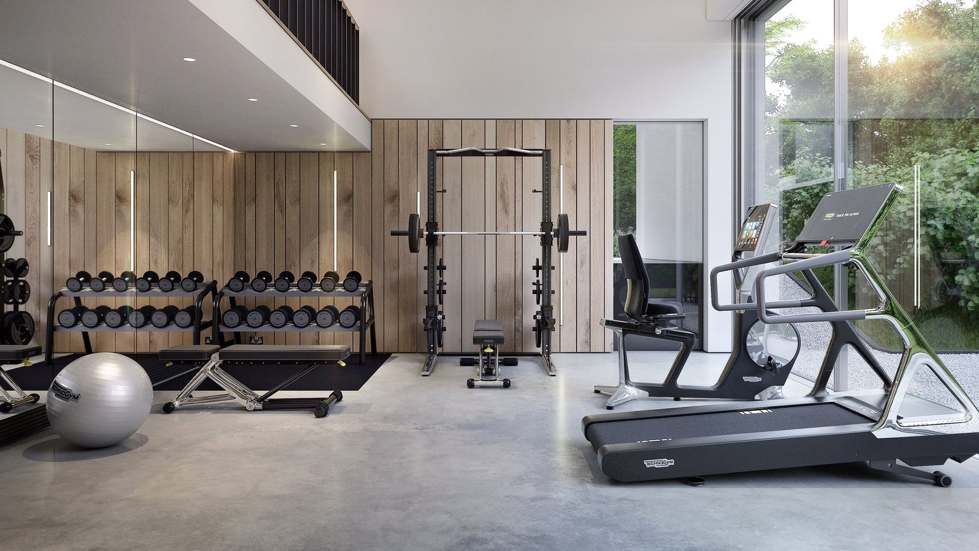 Un gimnasio moderno con diversos equipos, incluyendo mancuernas, una prensa de banca, una jaula para sentadillas y una cinta de correr.