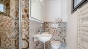 Een badkamer met een douche, toilet en wastafel.