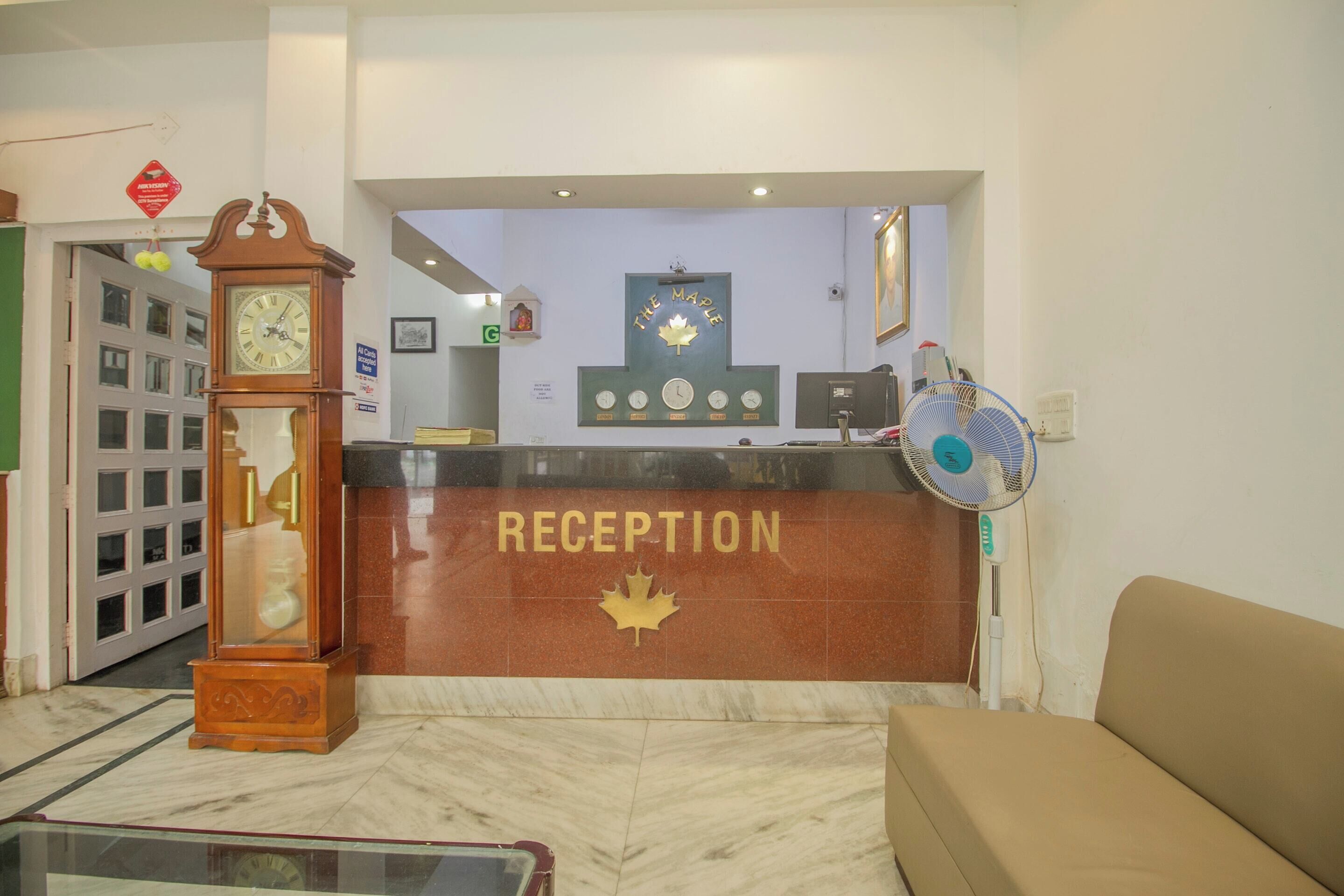 A reception area with a clock, a maple leaf emblem, and a fan.