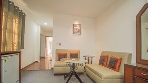 A compact living space with a sofa, a small round table, a refrigerator, and a mirror. - Collection O Sevoke Crossway Siliguri (Siliguri)