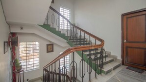 A staircase with a wooden handrail and metal balusters, leading to a landing with a door marked '204'. - Collection O Sevoke Crossway Siliguri (Siliguri)