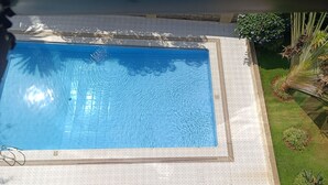 A rectangular swimming pool with a grid-patterned deck surrounding it. - Myra Residence (Nairobi)