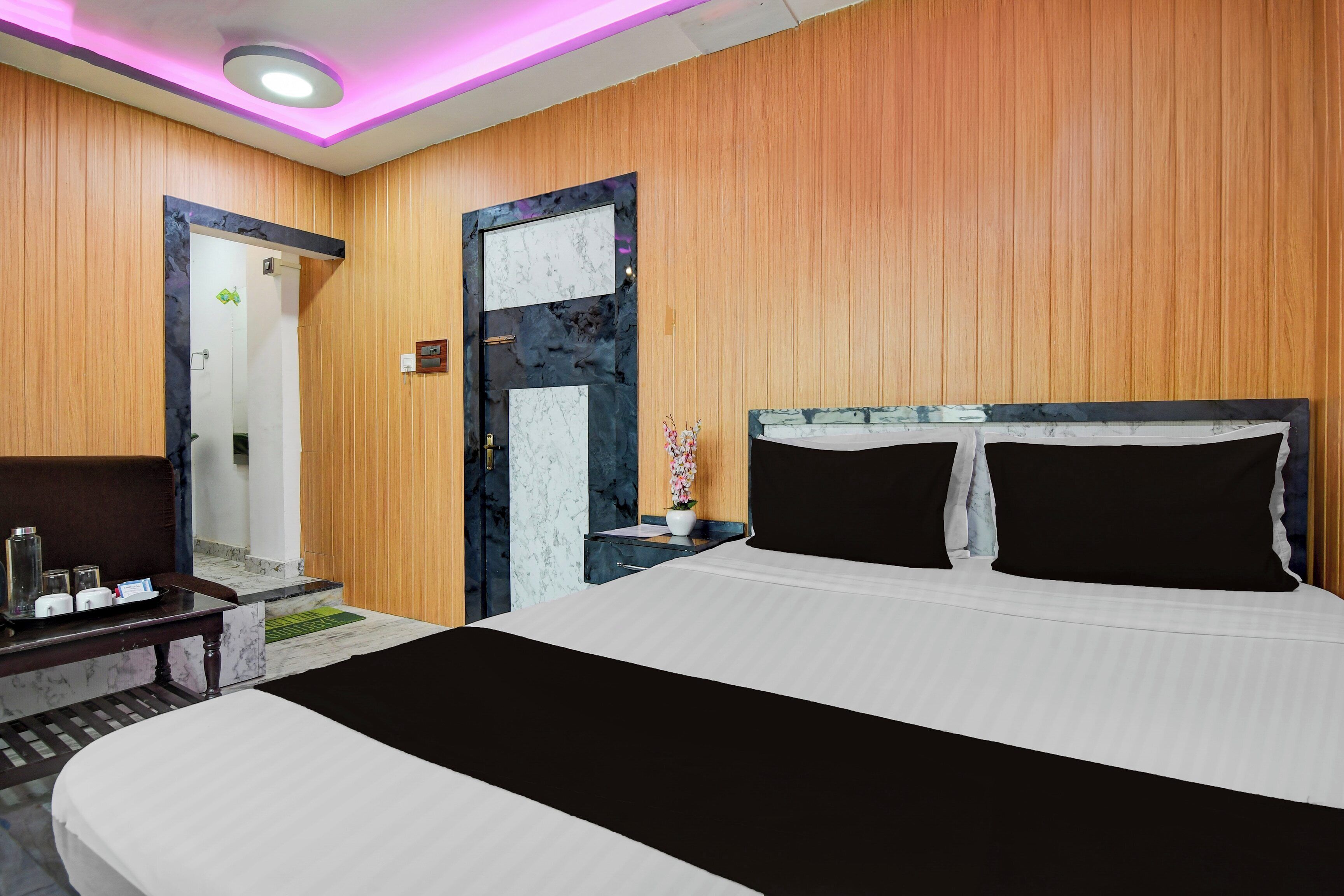 Een hotelkamer met een bed, nachtkastje en een lampje.