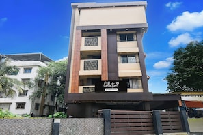 A multi-story building with a modern architectural design, featuring a prominent entrance with a sign.