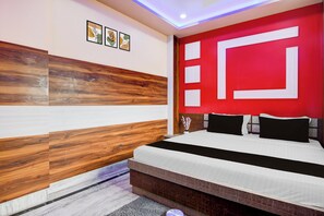 Un dormitorio moderno con cama, una pared de acento roja y paneles de madera.