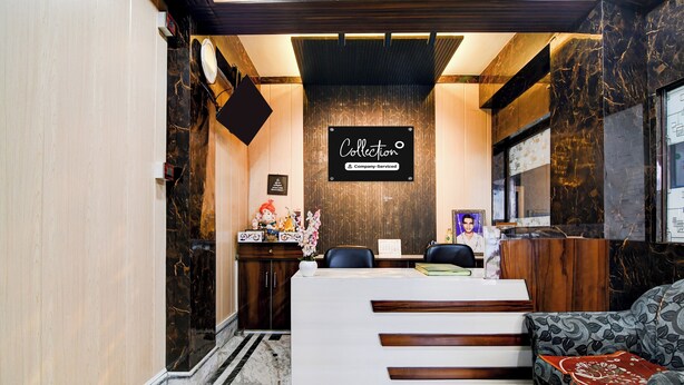 A reception area with a marble reception desk, a sofa, and a wall-mounted sign. - Collection O New Jalpaiguri Railway (Jalpaiguri)