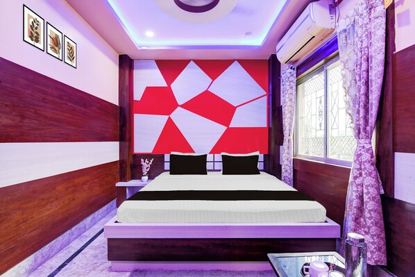 A modern bedroom with a geometric wall design, a bed with black and white bedding, and a window with purple curtains.