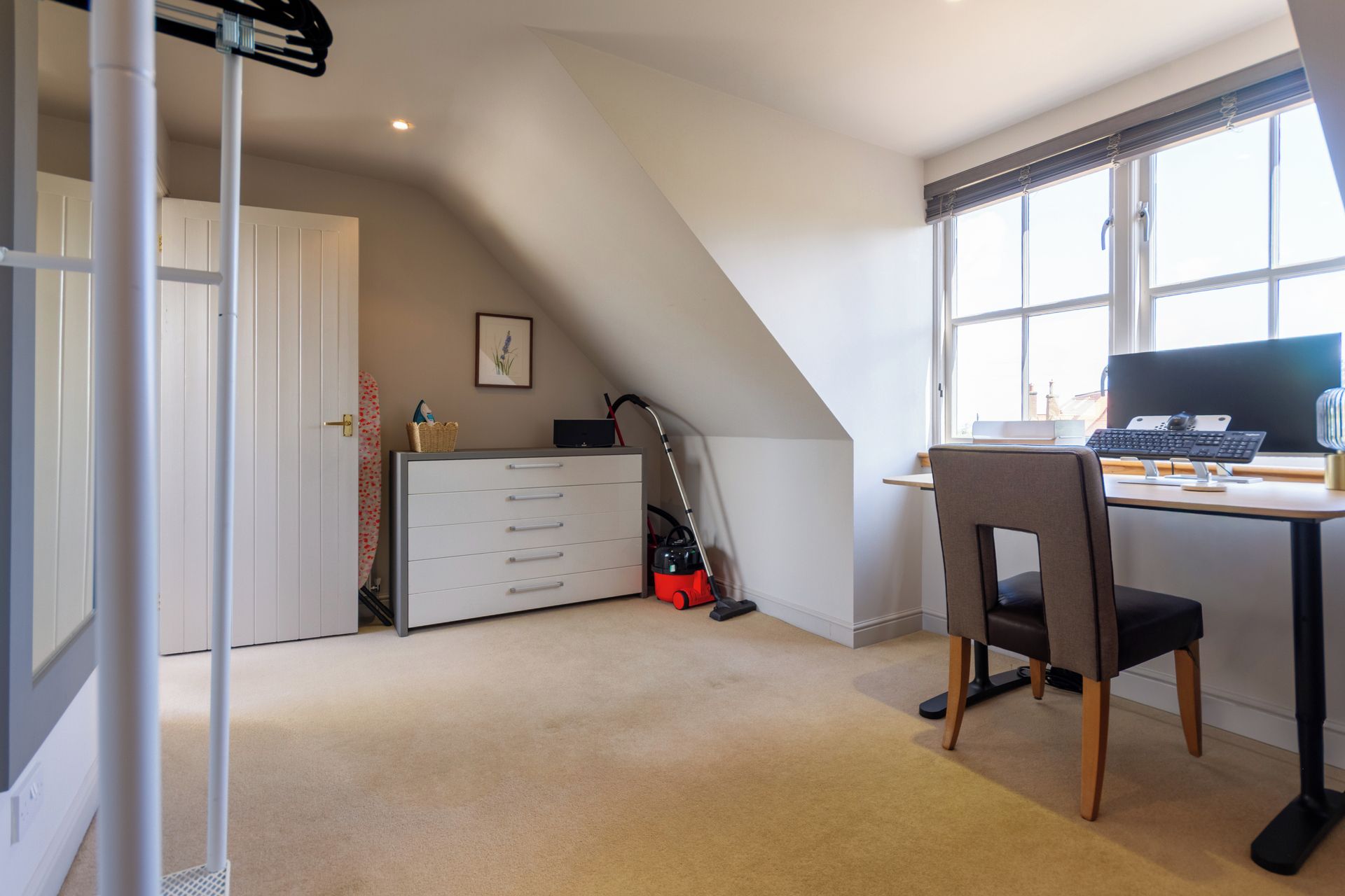 A room with a desk, chair, and a window.