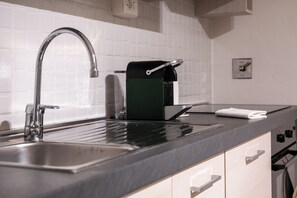 A kitchen with a stainless steel sink, a coffee machine, and a towel on the counter. - Ada-Aurora Penthouse - Rooftop & Duomo View (Firenze)