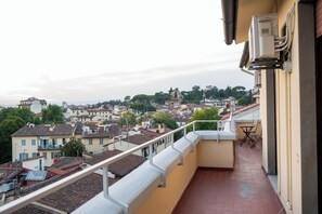 A balcony with a view of a residential area, including houses and trees. - Ada-Aurora Penthouse - Rooftop & Duomo View (Firenze)