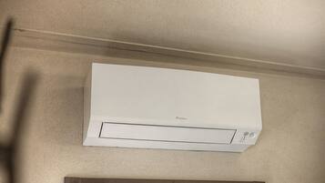 A white air conditioning unit mounted on a wall with a visible brand logo.