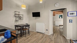 A modern kitchen with a dining table, chairs, and a hanging light fixture. - Accessible "Terre" Apartment near Garden with Wi-Fi and Air Conditioning (Dogliani)