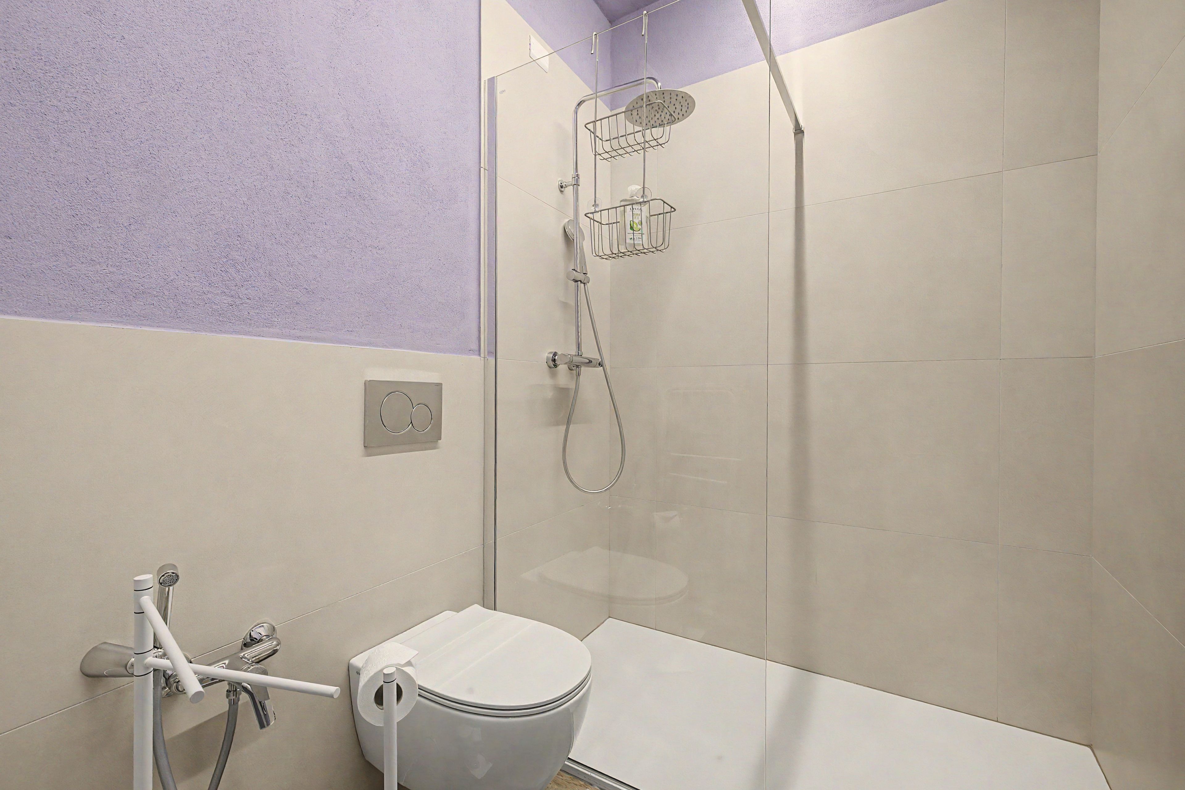 Un bagno moderno con doccia, wc e porta asciugamani.