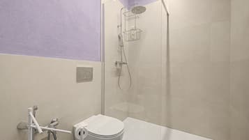 Un bagno moderno con doccia, wc e porta asciugamani.