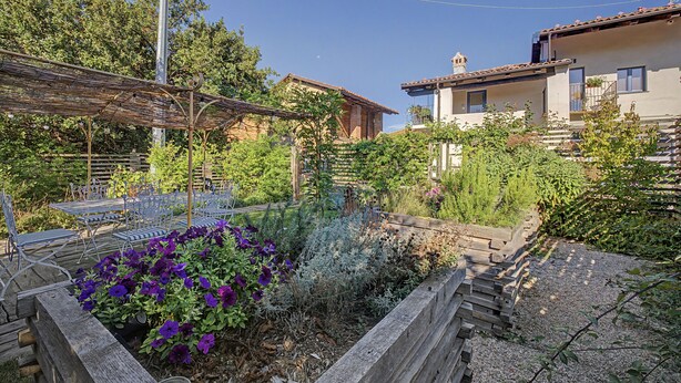 A garden with a pergola, seating area, and a variety of plants. - Accessible "Terre" Apartment near Garden with Wi-Fi and Air Conditioning (Dogliani)