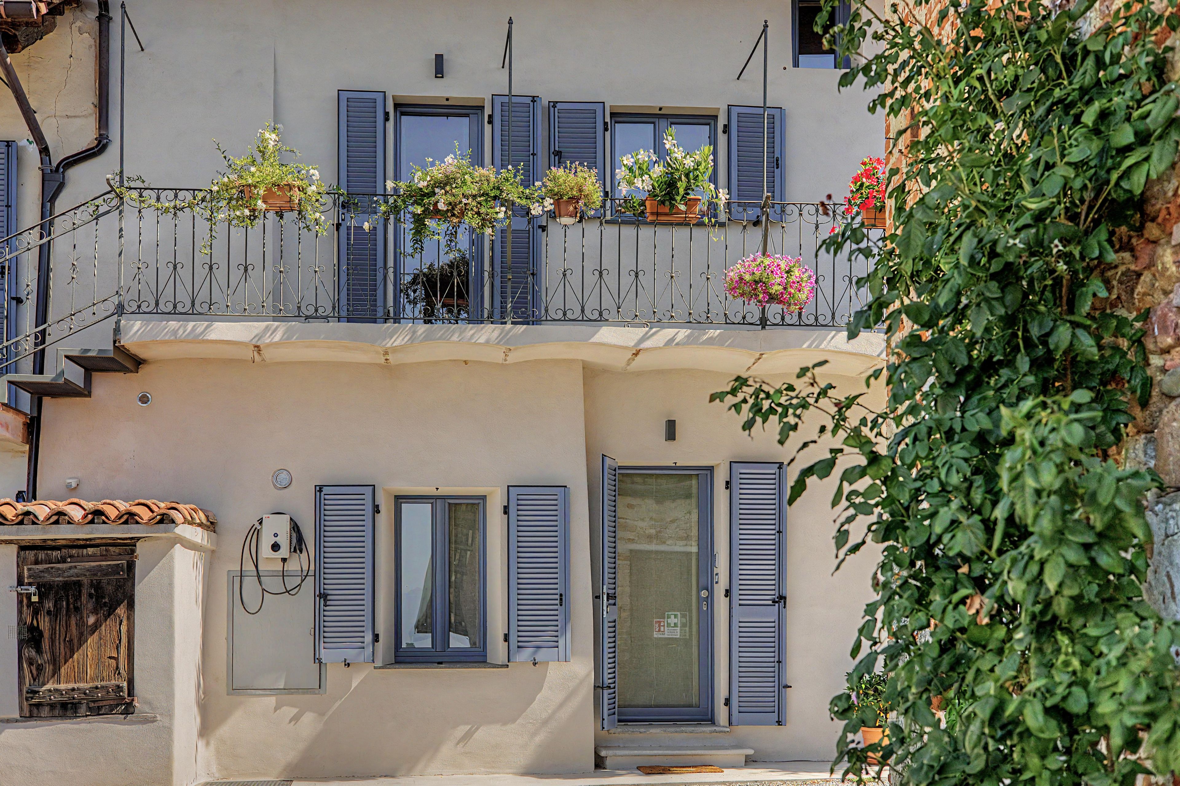 A building with a balcony adorned with potted plants and flowers.