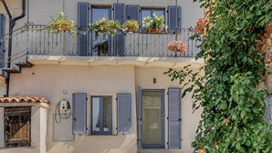 Ein Gebäude mit einem Balkon, der mit Blumentöpfen und Blumen geschmückt ist.