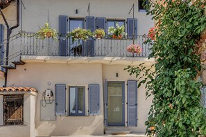 A building with a balcony adorned with potted plants and flowers.