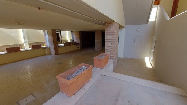 An interior space with a high ceiling, a brick column, and a large window. - APARAMENT 30MT FROM THE BEACH WITH TERRACE AND PARKING (San Vincenzo)