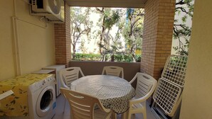 A small patio with a table and chairs, a washing machine, and a fan. - APARAMENT 30MT FROM THE BEACH WITH TERRACE AND PARKING (San Vincenzo)