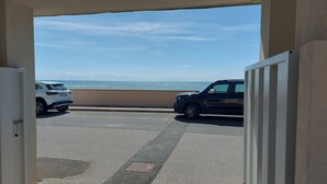A parking area with two cars, a view of the sea, and a clear sky. - APARAMENT 30MT FROM THE BEACH WITH TERRACE AND PARKING (San Vincenzo)