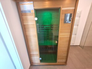 A glass elevator door with a green light, a metal handle, and a control panel with buttons. - Holiday apartment with infrared sauna, fireplace & terrace in Winterberg (Winterberg)