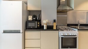 Una cocina moderna equipada con refrigerador, microondas, cafetera, estufa y horno.
