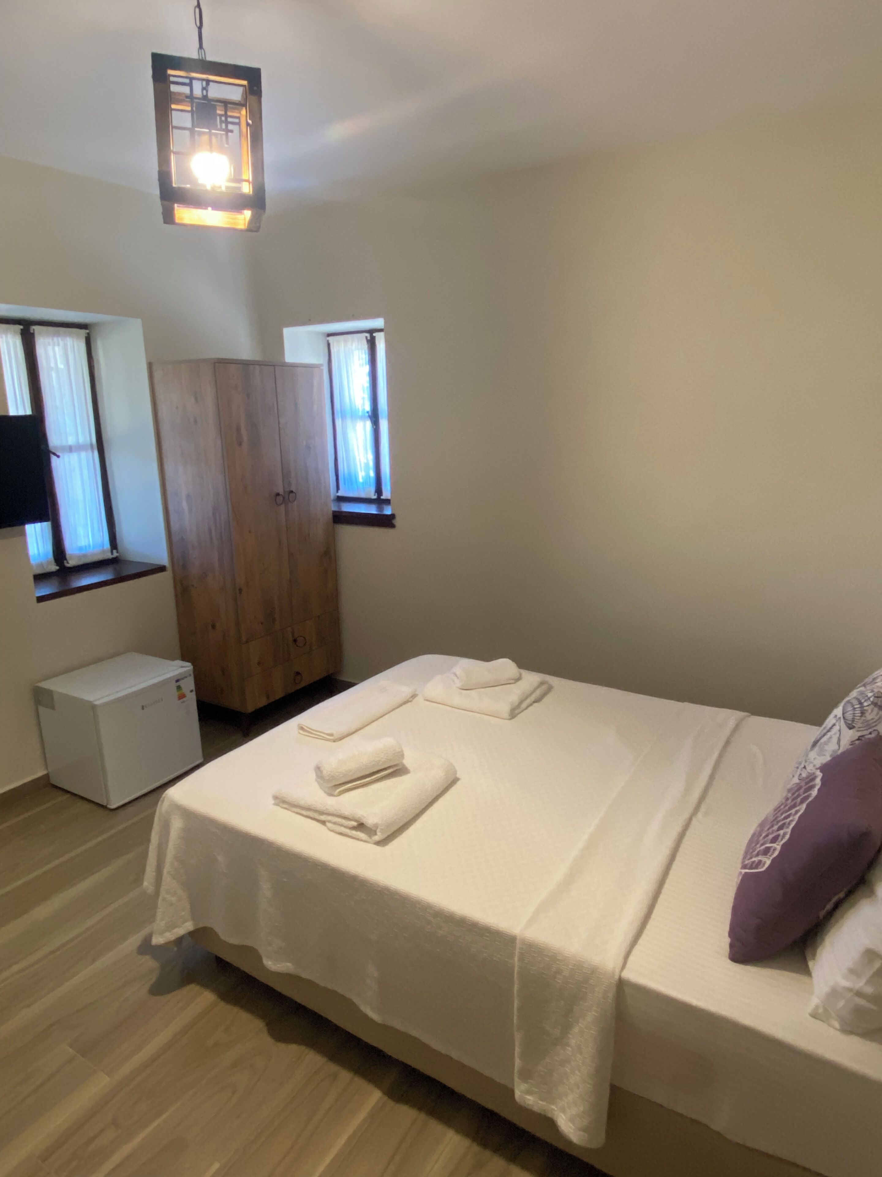 Ein Schlafzimmer mit Bett, Kleiderschrank, Heizung und Fenster.
