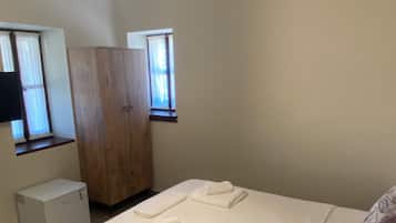 Ein Schlafzimmer mit Bett, Kleiderschrank, Heizung und Fenster.