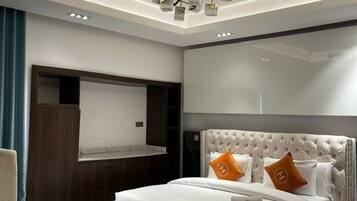 A modern bedroom with a large bed, a built-in TV, and a unique ceiling light fixture.