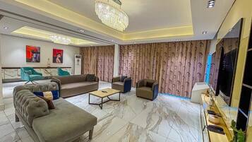 Deluxe Apartment, 3 Bedrooms, Balcony, City View | Living area | 50-inch LED TV with cable channels, Netflix, streaming services