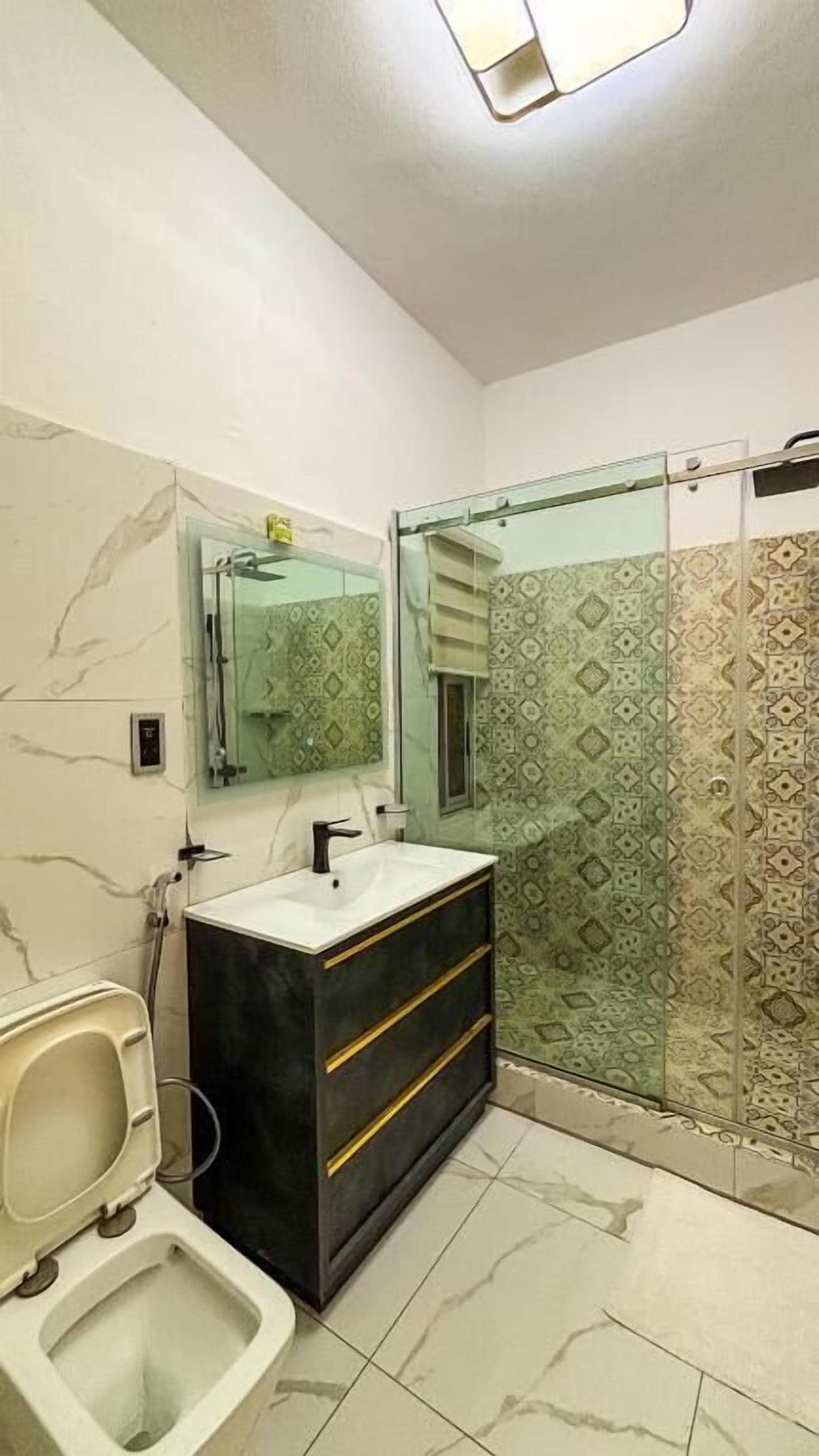 Un baño con inodoro, lavamanos y cabina de ducha.