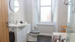 A bathroom with a toilet, sink, and mirror. - The Herring's Lean (Eyemouth)