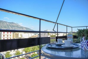A balcony with a table, two cups, and a tray.
