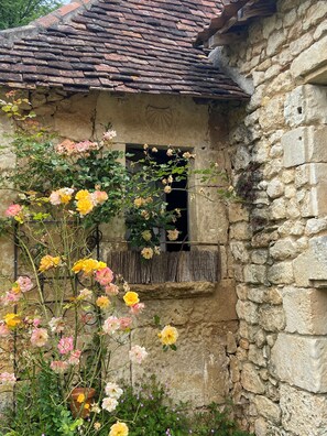 A rustic stone building with a weathered exterior and a traditional tiled roof. - Gîte du verger avec piscine dans un domaine périgourdin (Saint-Georges-de-Montclard)