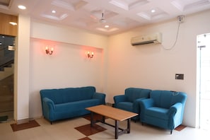A room with a blue sofa, a matching armchair, and a wooden table.