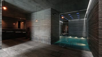 Ein moderner, überdachter Schwimmbereich mit minimalistischem Design, inklusive einer Betonwand und einem gläsernen Bereich.