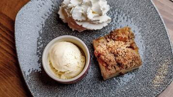 A dessert plate with a scoop of ice cream and a crumbly pastry.