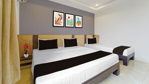 A hotel room with a large bed, two bedside tables, a ceiling fan, and two framed artworks on the wall. - Collection O Thiruparankundram City (Madurai)