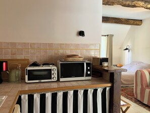 Eine Küche mit zwei Mikrowellen, einem Wasserkocher und einem Toaster auf der Arbeitsfläche.