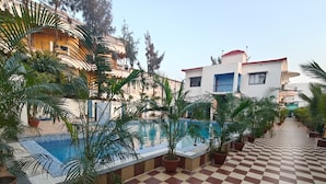 Zona de piscina en la azotea con plantas en macetas y suelo a cuadros.