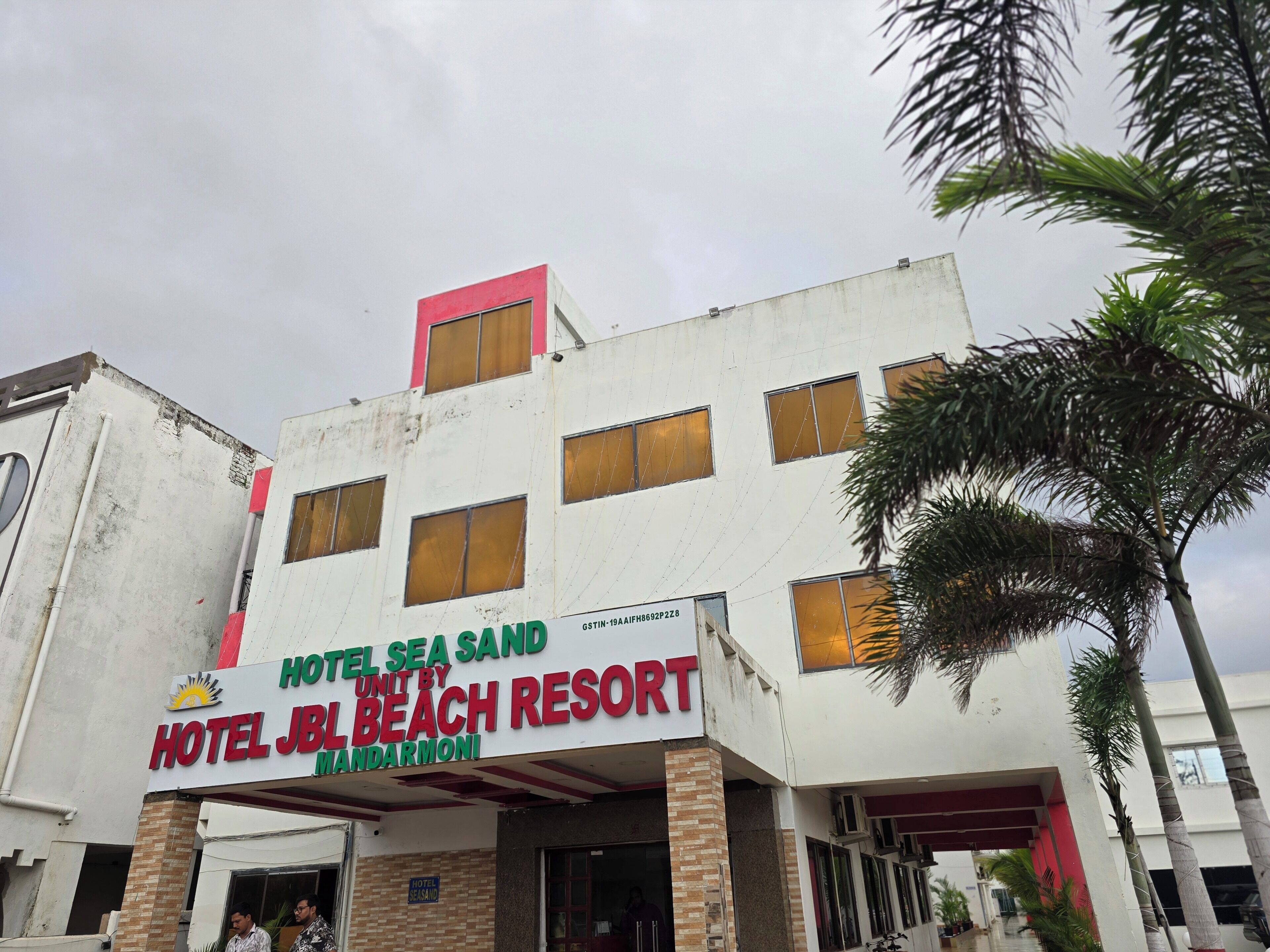 Un edificio de varios pisos con un letrero que indica 'Hotel JBL Beach Resort', una propiedad de JBL Beach Resort.
