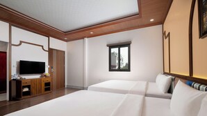 A hotel room with a large bed, a television, a desk with a computer, and a window with a view. - Ngoc Cherry (Hoa Lu)