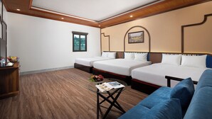 A hotel room with two beds, a sofa, a small table with a magazine, a window, and a painting on the wall. - Ngoc Cherry (Hoa Lu)