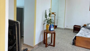 A room with a bed, a desk with a computer, a chair, and a potted plant. - TranoBe – Spacious, bright loft in Antananarivo, near downtown (Tananarive)