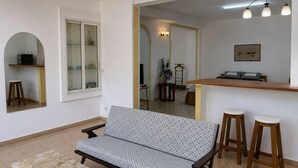 A living room with a sofa, a coffee table, and a bar area with stools. - TranoBe – Spacious, bright loft in Antananarivo, near downtown (Tananarive)