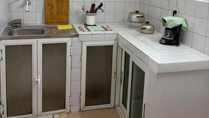 A compact kitchen with a sink, a wooden cutting board, a coffee maker, and a kettle. - TranoBe – Spacious, bright loft in Antananarivo, near downtown (Tananarive)
